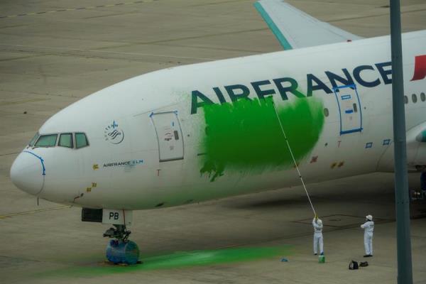 Activistas de Greenpeace pintan de verde un avión de Air France en el aeropuerto Charles de Gaulle para reclamar una reducción de vuelos.