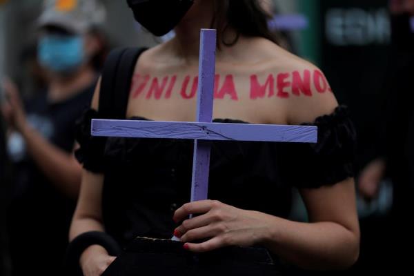 Una mujer marcha con una cruz durante una manifestación con motivo del Día Internacional de la Eliminación de la Violencia contra las Mujeres. EFE