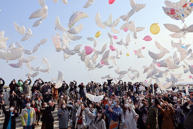 Personas lanzan globos con mensajes para las víctimas del devastador terremoto y tsunami de 2011 en Natori, Japón. Foto: EFE