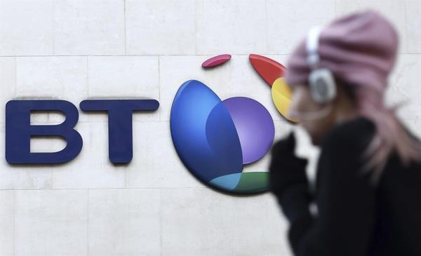 Un peatón camina junto al logotipo de la compañía British Telecom (BT) en su sede en Londres.