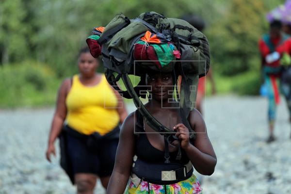 Una mujer migrante llega con su mochila en la cabeza, el 10 de febrero de 2021, a la comunidad de Bajo Chiquito, provincia del Darién (Panamá). Foto: EFE