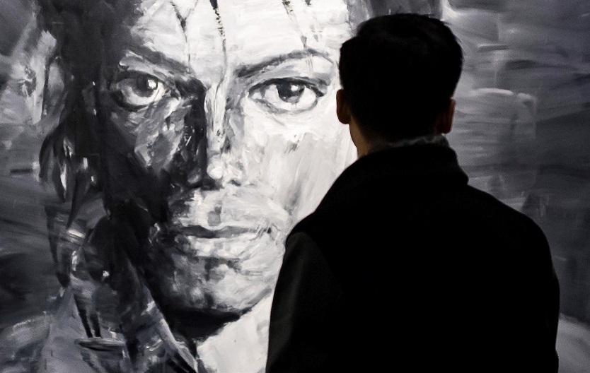 Un visitante observa las obras del artista chino Yan Pei-Ming de Michael Jackson. EFE