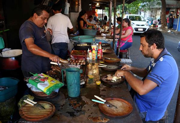Fotografía del 18 de marzo de 2016 de varias personas comiendo en un mercado de Asunción, Paraguay.