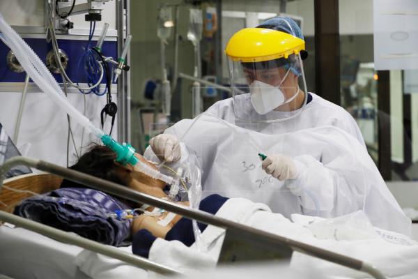 Personal médico trabaja con un paciente contagiado de coronavirus en una unidad de cuidados intensivos en el Hospital El Tunal, en Bogotá (Colombia). Foto: EFE