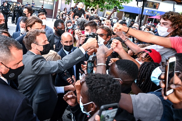 Emmanuel Macron (izq.) saluda, como es su costumbre, a miembros de una multitud durante su visita a Valence, Francia. Foto: EFE