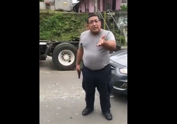 El agente policial, con arma de fuego en mano, no le importó que lo estuvieran grabando. 