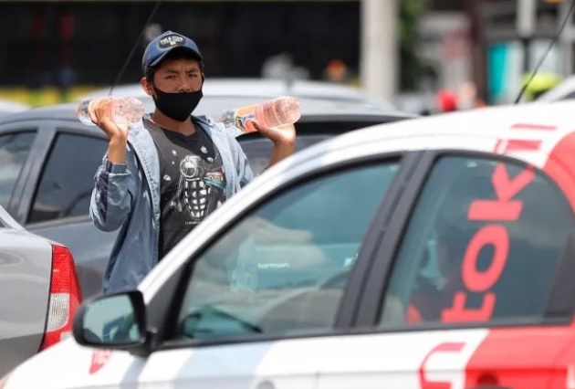 Un adolescente vende bebidas entre las filas de vehículos en Ciudad de México  Foto: EFE