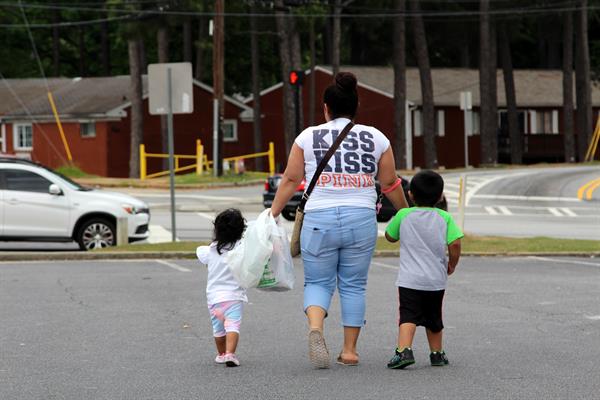 Una mujer camina con dos niños de la mano en Estados Unidos. Foto: EFE