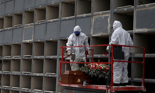 Personal realiza el entierro de una víctima de coronavirus en el cementerio Sao Franscisco Xavier en Río de Janeiro (Brasil). EFE