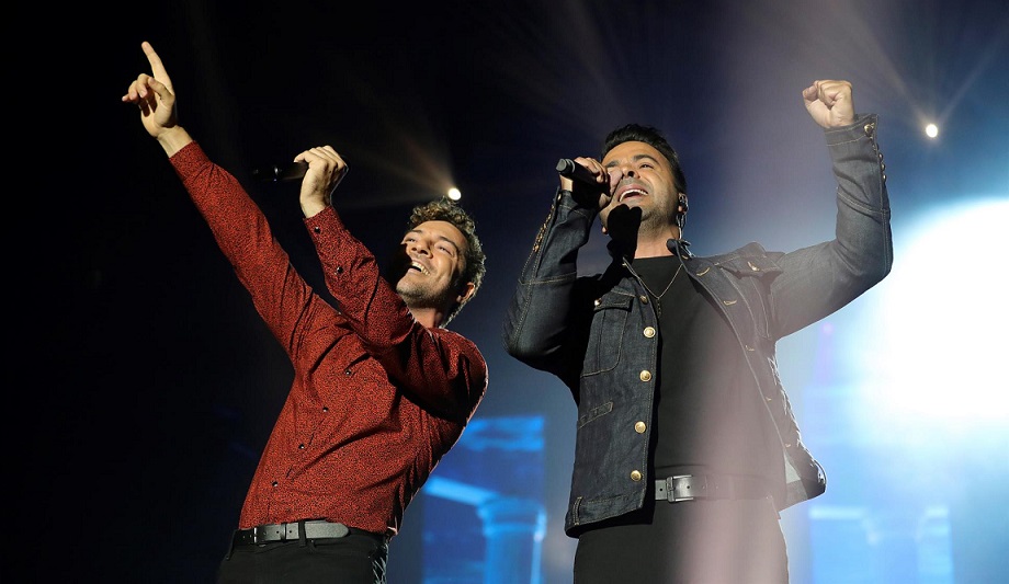 Los cantantes David Bisbal y Luis Fonsi durante un concierto. EFE/JuanJo Martín/Archivo