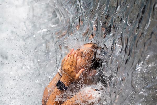 Una persona se refresca bajo una cascada en un parque en Washington, DC, Estados Unidos, este 30 de junio de 2021. Foto: EFE