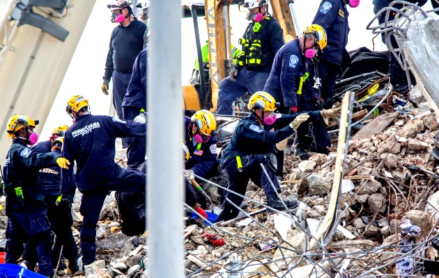 Miembros de equipos de rescate fueron registrados este lunes al reanudar sus labores sobre los escombros del edificio Champlain Towers South. Foto: EFE