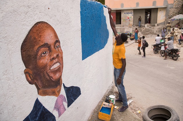 Un hombre pinta un mural en homenaje al presidente Jovenel Moise, en Puerto Príncipe, Haití. Foto: EFE