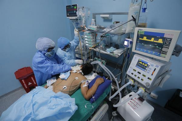 Trabajadores sanitarios atienden a un paciente con covid-19 en una de las Unidades de Cuidados Intensivos del Hospital Alberto Sabogal, en el Callao (Perú). EFE
