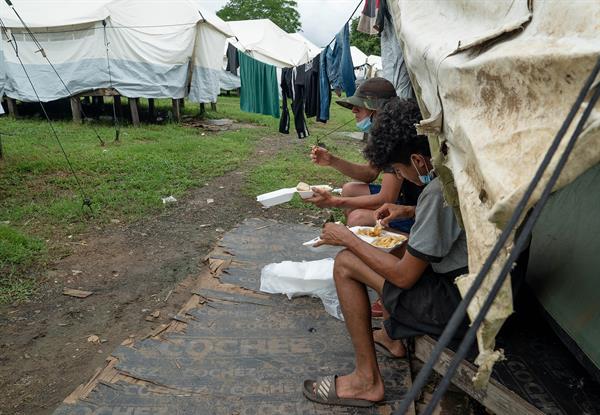 Migrantes comen en un centro de recepción en la región del Darién, selva que separa Colombia de Panamá. EFE