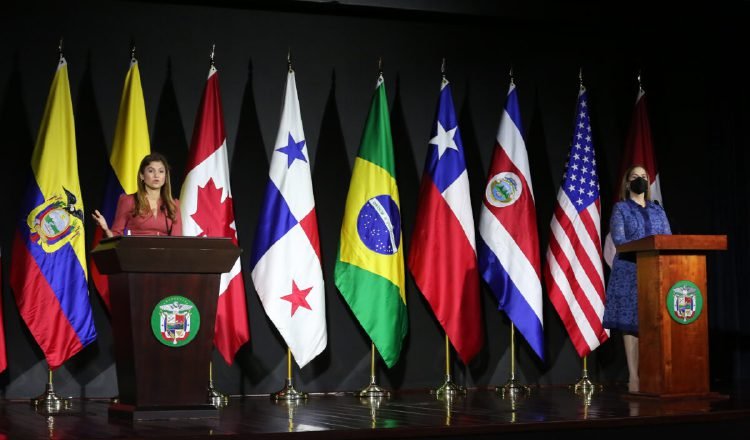 La canciller y la directora de Migración dan detalles de lo discutido en la reunión, con las banderas de los países participantes, al fondo. Foto: Cortesía Cancillería 