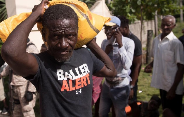 Un hombre carga ayuda humanitaria entregada por una entidad privada hoy, en las afueras de Les Cayes (Haití). Foto: EFE