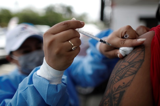 Un hombre recibe una dosis de la vacuna Pfizer contra el coronavirus, en los estacionamientos del estadio Rommel Fernández Gutiérrez. Foto: EFE