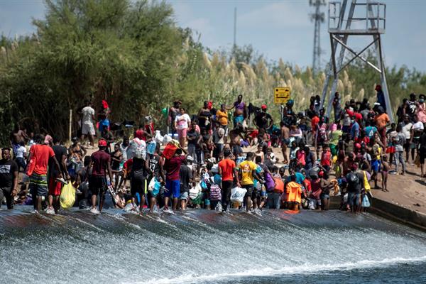 Migrantes procedentes de Haití esperan ayer en el río Bravo para cruzar rumbo a Estados Unidos, en Ciudad Acuña, estado de Coahuila (México). EFE