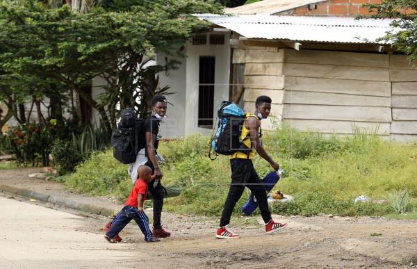 Migrantes caminan por la localidad colombiana de Necoclí, en la frontera con Panamá. Foto: EFE