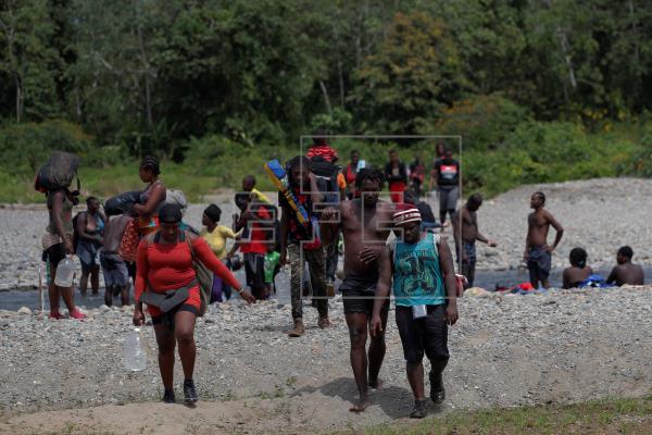 Migrantes haitianos caminan a través del río turquesa hacía la comunidad de Bajo Chiquito, en la provincia de Darién. Foto: EFE