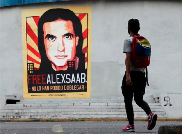 Un hombre pasa frente a un cartel de apoyo al empresario colombo-venezolano Alex Saab, en Caracas (Venezuela). Foto: EFE