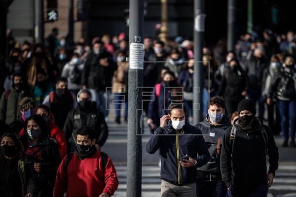 Personas caminan frente a la estación ferroviaria de Constitución protegidos con mascarillas, en Buenos Aires, Argentina. Foto: EFE