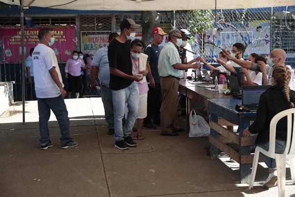 Un grupo de personas se prepara para votar en la junta receptora de votos durante las elecciones presidenciales en Managua. Foto: EFE