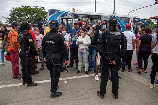 Policías vigilan mientras familiares de presos esperan información sobre sus seres queridos, en las afueras de la penitenciaría de Guayaquil (Ecuador). EFE