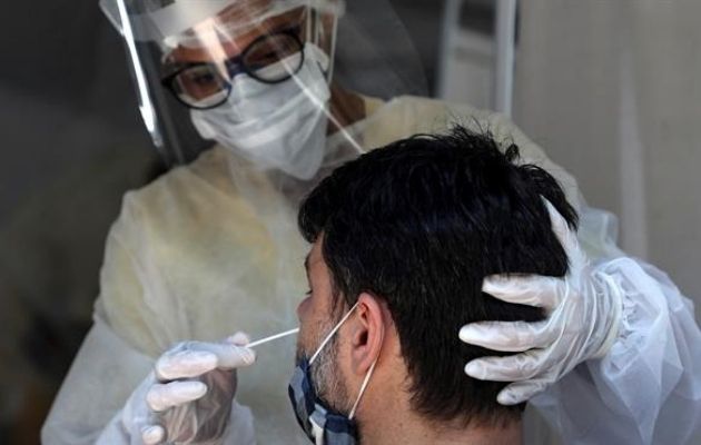 Personal médico le toma la prueba de coronavirus a un hombre en São Gonçalo, estado de Río de Janeiro (Brasil). EFE