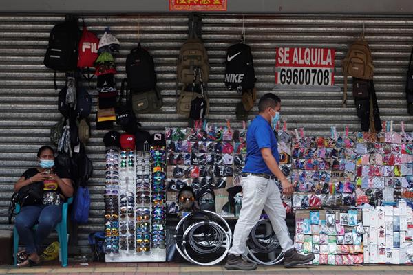 Una mujer trabaja en un puesto improvisado de venta de artículos en la avenida central de la Ciudad de Panamá. EFE