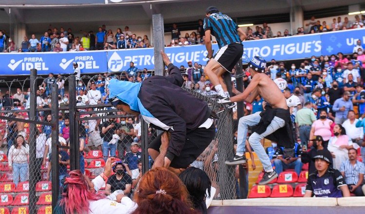 Aficionados se lanzan a la cancha durantel el partido Querétaro- Atlas. Foto:EFE