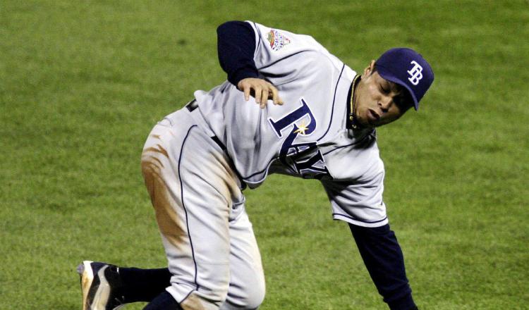 El jugador de los Rays de Tampa Bay Akinori Iwamura comete un error al dejar escapar una bola de Jimmy Rollins de los Fílis de Filadelfia. Foto: EFE / Chris Gardner 