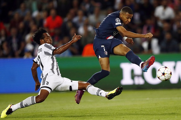 Juan Guillermo Cuadrado de la Juventus (izq.) intenta marcar a Kylian Mbappe del PSG en el partido entre ambos en la Champions. Foto:EFE