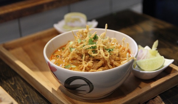 El plato consiste en un caldo de leche de coco con pollo en el que se combinaron numerosas influencias culinarias. Foto: EFE/ Nicole Protonentis