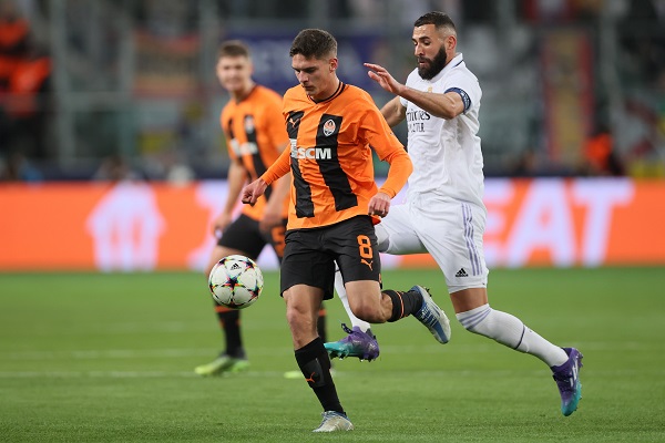 Georgiy Sudakov de Shakhtar Donetsk (izq.) conduce e balón ante la marca de Karim Benzema del Real Madrid. Foto:EFE