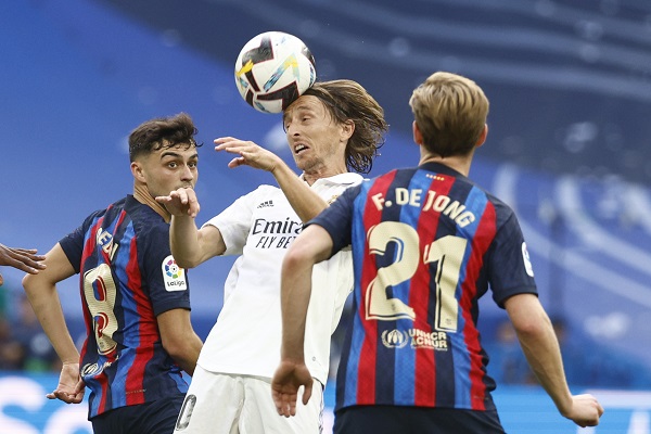 Los centrocampistas del FC Barcelona Pedri (i) y Frenkie de Jong (d) acechan al centrocampista del Real Madrid Luka Modrić (c). Foto: EFE