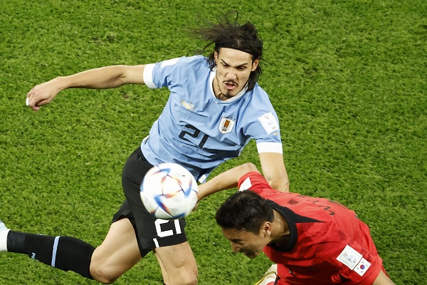 Edinson Cavani (izq.) disputa el balón con Jung Woo-young de Corea del Sur. Foto:EFE