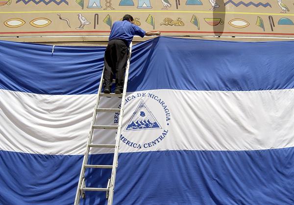 Un empleado del Casino Pharaos de Managua instala una bandera gigante de Nicaragua con motivo de la celebración del 182 Aniversario de la Independencia. EFE