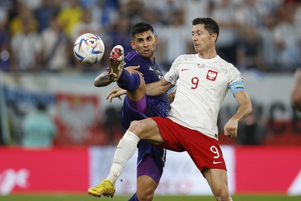 Robert Lewandowski de Polonia (9) disputa un balón con Cristian Romero de Argentina. Foto: EFE