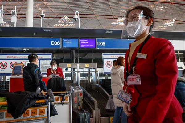 Personal de las líneas aéreas atiende a los pasajeros en el Aeropuerto Internacional de Pekín el 30 de noviembre de 2022. EFE
