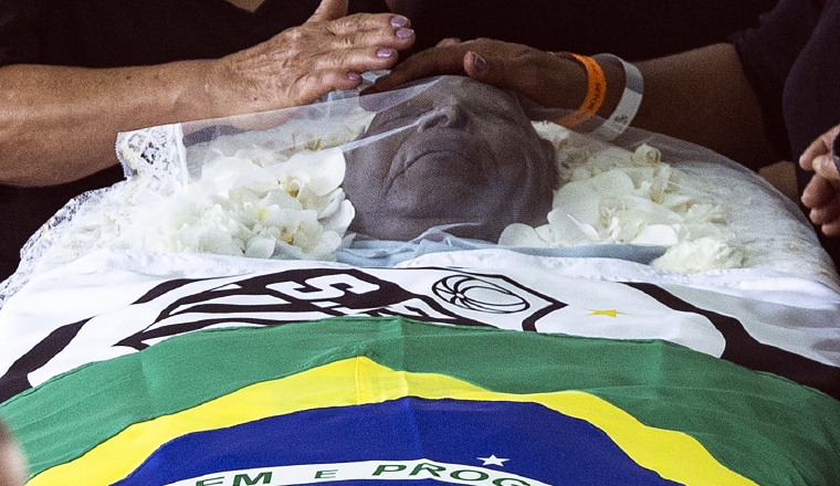 Una bandera nacional de Brasil y una del club Santos envuelven el cuerpo de la leyenda del fútbol Pelé. Foto:EFE