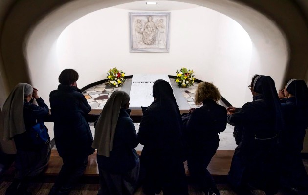 Fieles rezan ante la tumba del papa emérito Benedicto XVI en las Grutas del Vaticano, Ciudad del Vaticano. Foto:EFE