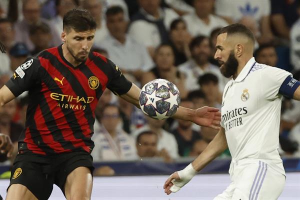 El delantero francés del Real Madrid, Karim Benzema (d), disputa el balón ante el defensa portugués del Manchester City, Rubén Dias. Foto: EFE