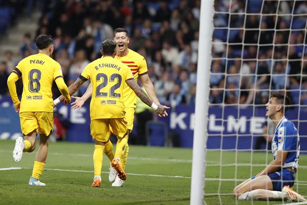 Lewandowski celebra un gol del Barcelona, ante la mirada del defensa del Espanyol César Montes (d). Foto: EFE