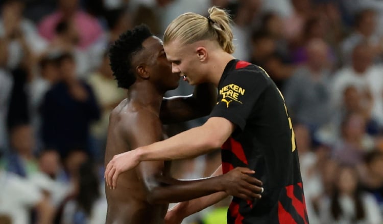 El delantero brasileño del Real Madrid, Vinicius Jr. (izq) y el noruego del Manchester City, Erling Haaland, se saludan durante el partido de ida de las semifinal de la Champions. EFE