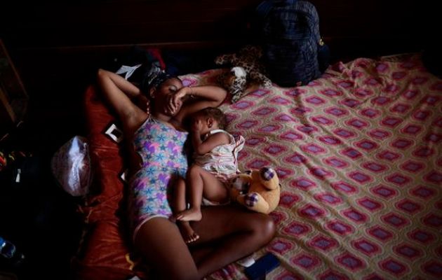 Una migrante venezolana junto a su hijo descansan en un albergue temporal tras cruzar la selva del Darién. Foto: EFE