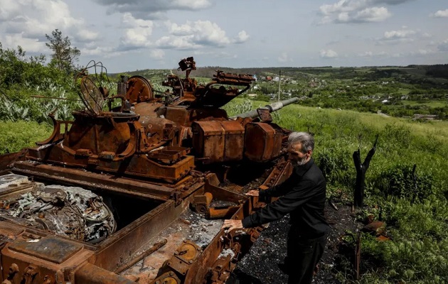Un residente junto a un tanque ruso quemado, en el pueblo de Bohorodychne, región de Donetsk. Foto: EFE