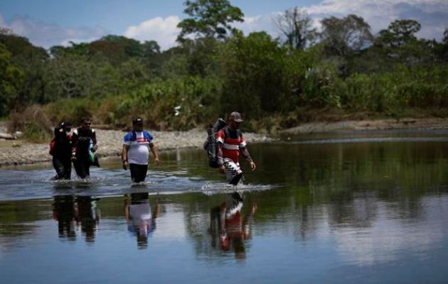Migrantes cruzan el río Tuquesa, en Darién (Panamá). Foto: EFE
