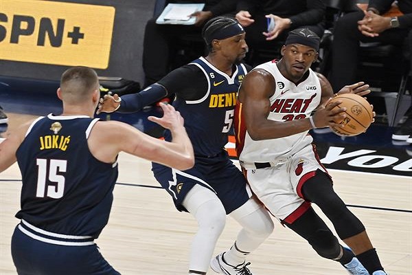 El alero de los Miami Heat, Jimmy Butler (der.), conduce hacia la canasta mientras es acechado por el alero de los Denver Nuggets, Aaron Gordon. Foto:EFE 